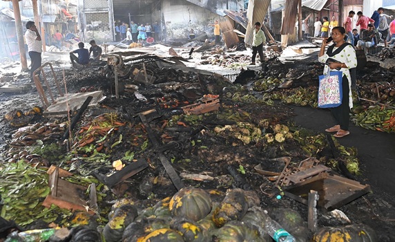 Shop owners and vendors were seen in front of their burnt shops and vegetables last night at Battala Market in Agartala. The fire destroyed 155 shops; the estimated loss is expected to exceed Rs 2 crore.