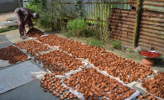 Potter gathers dried earthen lamps for Diwali, as homes prepare for the Hindu festival of lights. PIC- Abhisek 